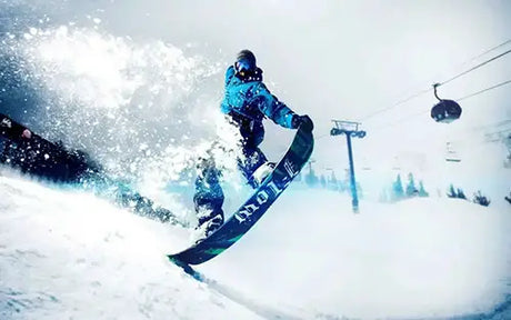 Snowboarder performing a jump while spraying snow.