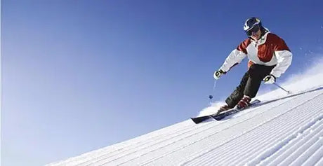 Skier carving down a snowy slope.