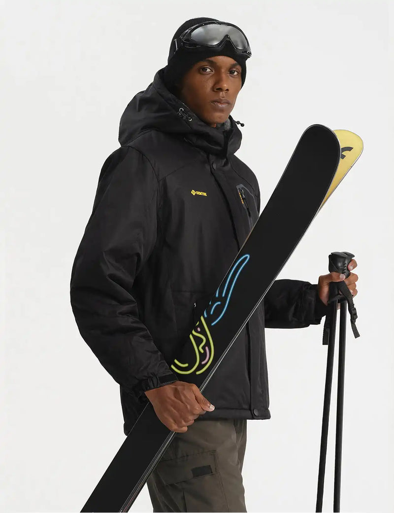 Skier wearing a black jacket and holding skis and poles.